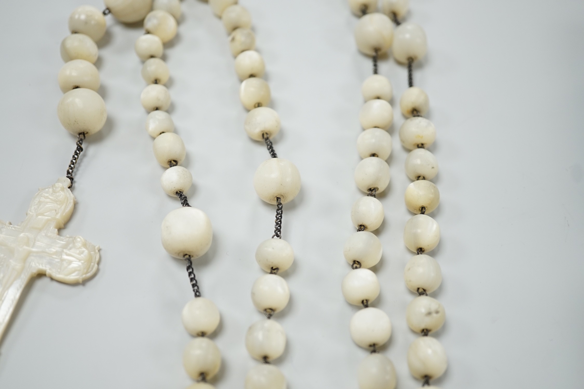 A long mother of pearl rosary, 158cm, with carved mother of pearl crucifix pendant, 8cm.